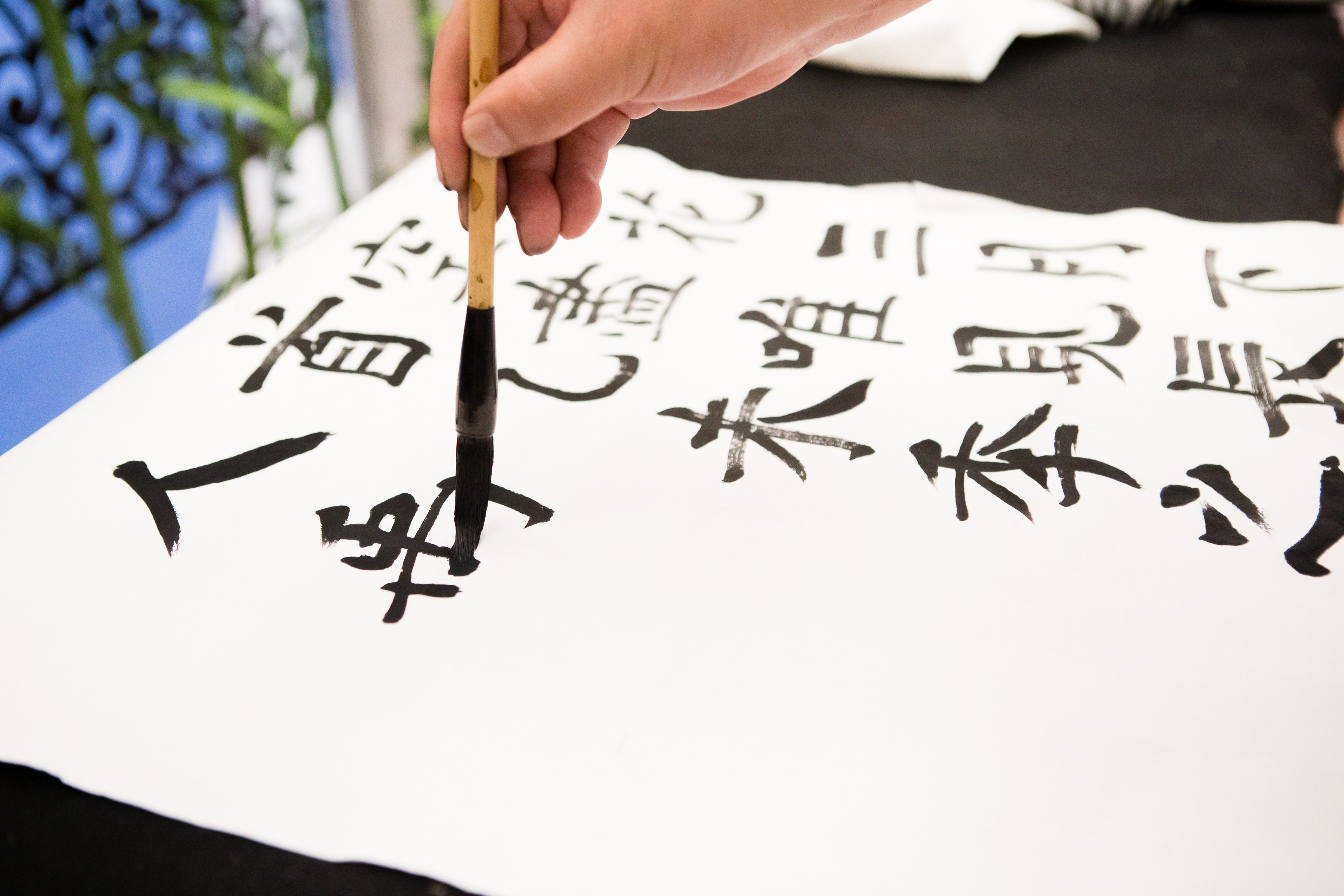 An image of someone doing Chinese calligraphy with a paintbrush. 