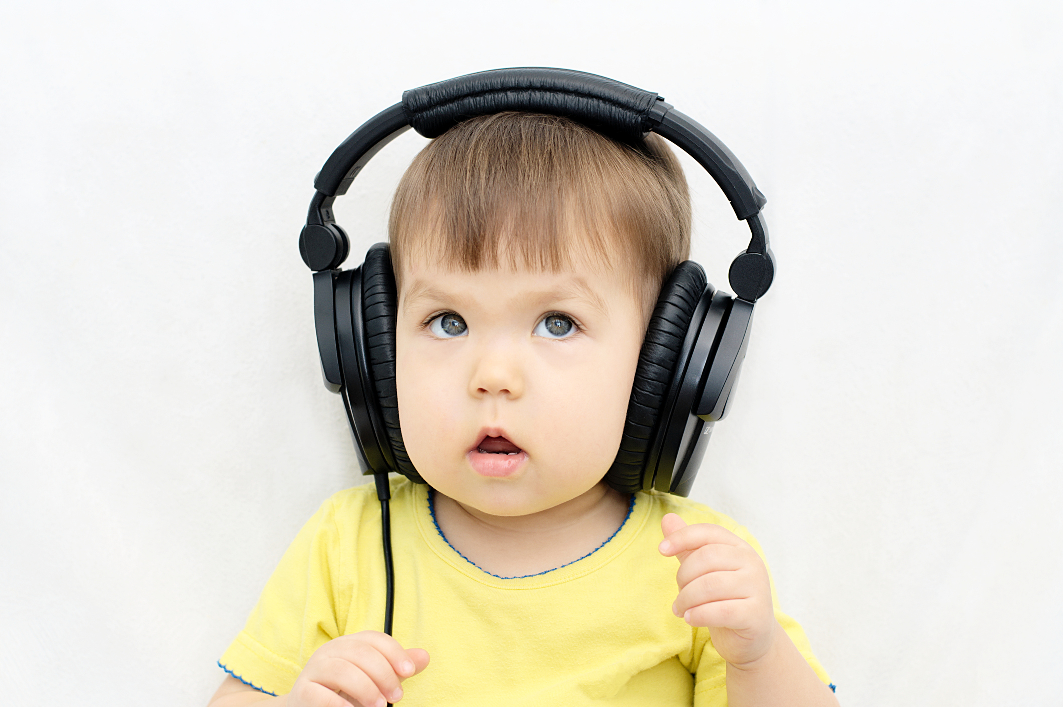 Image of a baby listening to earphones.