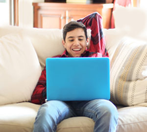 Teen boy interacting with tutor during online foreign language learning lesson.