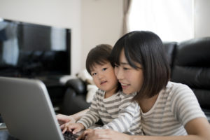 Mother and toddler using program on laptop computer.