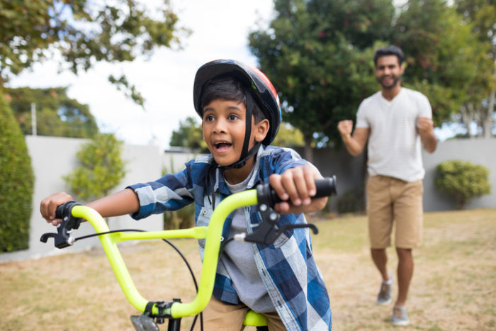 Father watching his son ride a bike.