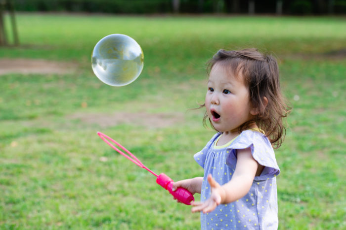 Young girl blowing bubbles.