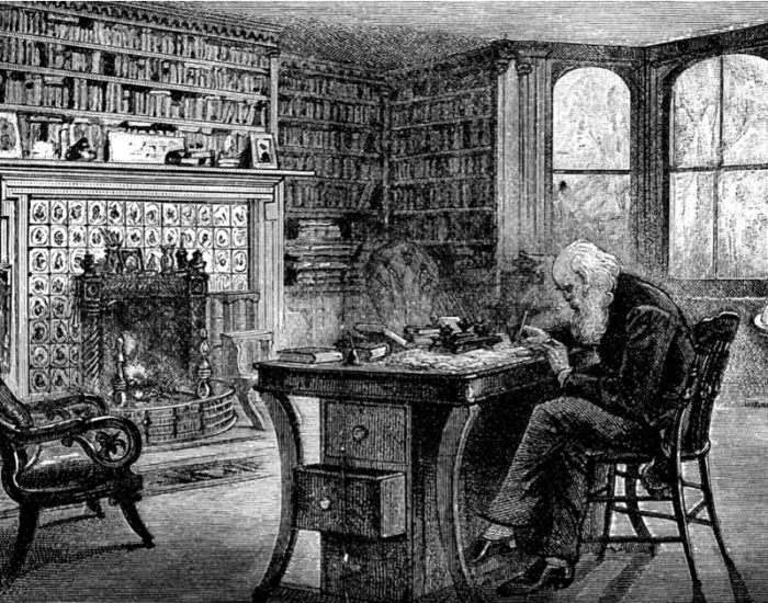 Image of Santa Claus working at a desk in his library. 